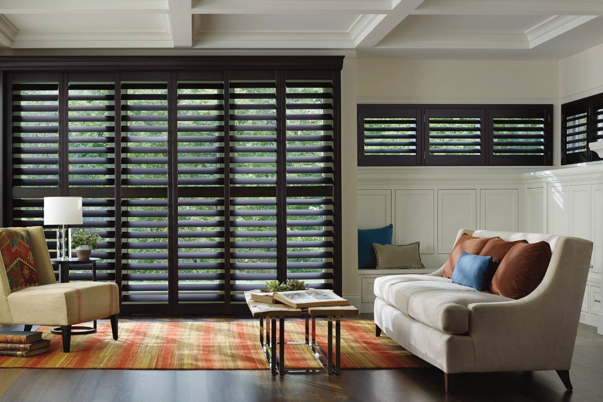 Living room with dark Hunter Douglas Heritance® Hardwood Shutters on the windows